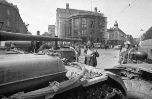 Muž s odhalenou hrudou pred okupacným tankom