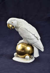 Porcelánová soška papagája na zlatej guli